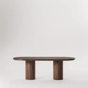 Könnte beinhalten: Ein langer, ovaler Holztisch mit zwei zylindrischen Beinen an jedem Ende. Der Tisch ist aus dunklem Holz mit einer natürlichen Maserung.