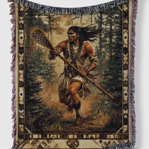 May include: A woven tapestry throw blanket featuring a Native American man running through a forest with a lacrosse stick. The man is wearing traditional clothing and has a painted face. The background is a forest with trees and foliage.
