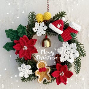 May include: A festive Christmas wreath with crocheted decorations. It features red poinsettias, white snowflakes, a gingerbread man, and a miniature Santa hat and stocking. The words "Merry Christmas" are displayed.