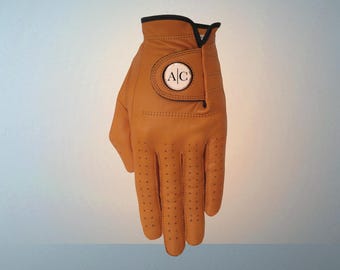 Heren cadeau. Oranje leer personaliseerde de eerste golfhandschoen van het luxeleer van het monogram. Marker voor aandenken