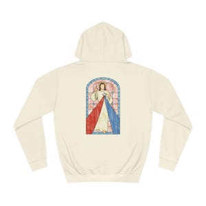 May include: A cream-coloured hooded sweatshirt with a stained glass image of Jesus Christ on the back. The image features a red and blue heart with rays of light emanating from it.