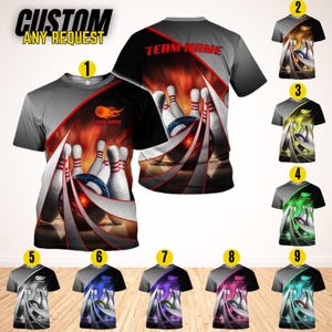 May include: A collection of bowling-themed t-shirts. The shirts feature a design of bowling pins and a ball, with a fiery background. The text "CUSTOM ANY REQUEST" is at the top. The shirts come in various color schemes.