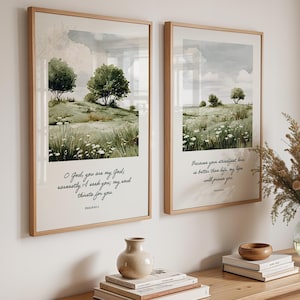 May include: Two framed wall art prints featuring watercolour landscapes of green hills, trees, and white flowers. The left print displays the text O God, you are my God; earnestly I seek you; my soul thirsts for you. Psalm 63:1. The right print displays the text Because your steadfast love is better than life, my lips will praise you. Psalm 63:3.