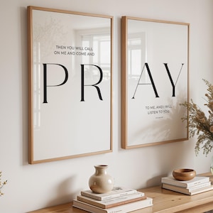 May include: Two framed wall art prints with the words "PRAY" and "PR" in large black letters. The prints have a light background and are in wooden frames. The text "THEN YOU WILL CALL ON ME AND COME AND" and "TO ME, AND I WILL LISTEN TO YOU" are also visible.