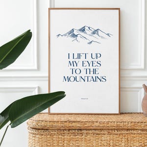 May include: A framed print with a blue mountain illustration and the text "I lift up my eyes to the mountains, Psalm 121". The print is on a white background and has a wooden frame.