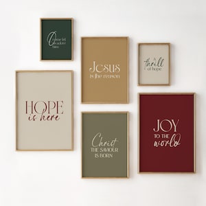 May include: A set of framed art prints with gold frames and different coloured backgrounds. Each print displays elegant white script with phrases such as "Hope is here," "Jesus is the reason," and "Joy to the world."