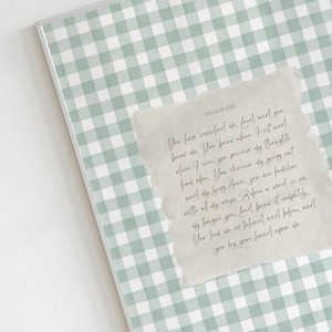 May include: A framed print with a pale green and white gingham design. A textured paper overlay features a handwritten script of Psalm 139. The frame is silver.
