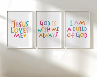 May include: Three framed art prints with white borders and colorful text. The prints read "JESUS LOVES ME", "GOD IS WITH ME ALWAYS", and "I AM A CHILD OF GOD". The text is in various colors, including blue, yellow, pink, and orange, against a white background.