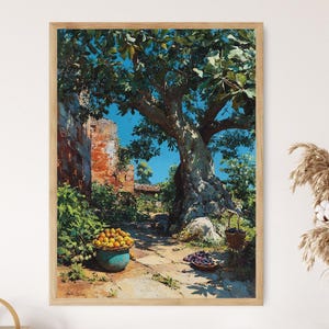 May include: A framed print of a sunlit outdoor scene. A large tree dominates the center, with a stone building on the left. A blue pot of oranges and a basket of grapes sit on the ground. The sky is a bright blue.