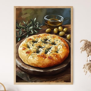 May include: A close-up of a round, golden brown flatbread with a crispy crust and a sprinkle of herbs. The bread is on a wooden surface with green olives and a glass jar of olive oil.