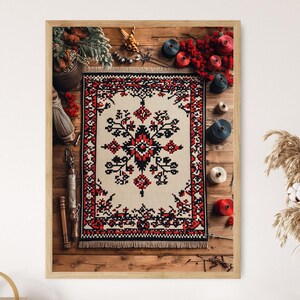 Puede incluir: Una imagen enmarcada de una alfombra tradicional con un patrón geométrico rojo, negro y blanco. La alfombra está rodeada de carretes de hilo de madera en varios colores, incluyendo rojo, azul y blanco.