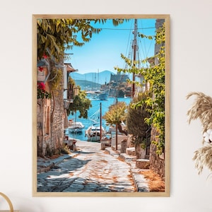 May include: A narrow cobblestone street lined with stone buildings and lush greenery leads to a view of a harbor with boats and a distant island.