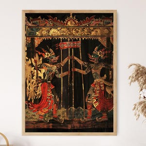 May include: Framed artwork depicting two figures in traditional attire, holding a banner. The figures have green faces, red and gold clothing, and are set against a black backdrop with gold accents. The artwork is framed in a light wood.