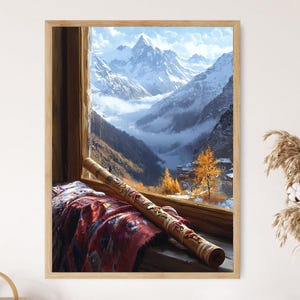 Puede incluir: Una impresión enmarcada de un paisaje montañoso visto a través de una ventana. Una flauta larga de madera decorada descansa sobre una tela roja y marrón estampada. La ventana revela montañas nevadas y un valle.