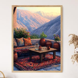 Op de afbeelding: Een kleurrijk tapijt met een geometrisch patroon ligt op een terras met een houten tafel en stoelen. Het terras kijkt uit op een bergketen met een blauwe lucht en witte wolken. Er staan potplanten op het terras.