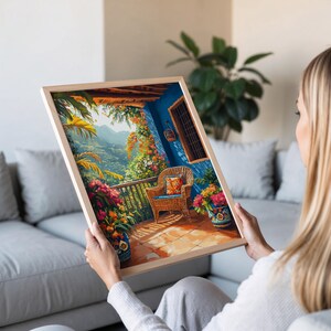 May include: A framed print depicting a vibrant balcony scene. The artwork showcases a blue wall, a wicker chair with a patterned cushion, and colorful flowers in pots. The balcony overlooks a lush green mountain landscape.