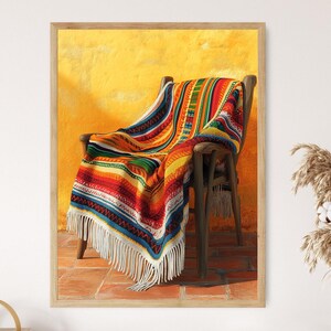 May include: A colorful woven blanket draped over a wooden chair against a yellow wall. The blanket has red, yellow, green, blue, and white stripes with fringe.