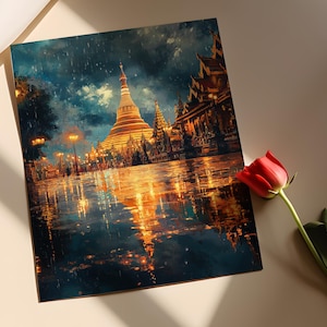 May include: A square art print depicting a golden pagoda and other buildings at night, with reflections in the wet ground. The artwork has a painterly style with dark blues, golds, and oranges. A red rose lies nearby.