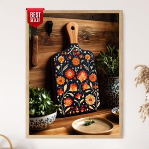 Könnte beinhalten: Ein rechteckiges Holzschneidebrett mit Griff, das eine dunkelblaue Oberfläche mit einem lebendigen Blumenmuster in Orange, Rot und Gelb aufweist. Das Brett ist aufrecht vor einer Holzwand platziert und mit einem roten Best Seller-Etikett versehen.