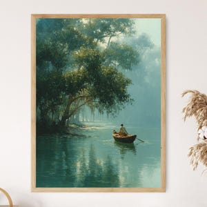 Könnte beinhalten: Ein gerahmter Kunstdruck zeigt eine ruhige Flussszene. Eine Person rudert in einem kleinen Boot auf dem ruhigen Wasser, unter einem großen Baum mit hängendem Moos. Das Kunstwerk ist in Grün-, Blau- und Brauntönen gehalten.
