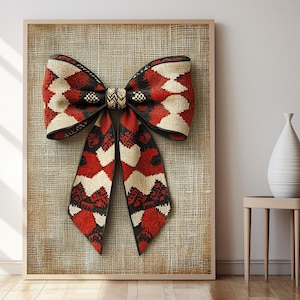 May include: A large red, white, and black bow with a geometric pattern is displayed on a burlap background. The bow is tied with a black cord.
