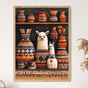 以下が含まれることがあります： 装飾的な花瓶と2匹のラマのフィギュアが描かれた額入りのプリント。花瓶はオレンジ、青、白で幾何学模様が施されています。ラマは白くふわふわです。素朴でボヘミアンなテーマのアートワークです。