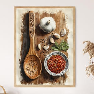 May include: A framed watercolour print depicting a wooden spoon with carved details, a garlic bulb, cloves, a small bowl of diced vegetables, and herbs. The artwork has a rustic, culinary theme, with a warm colour palette.