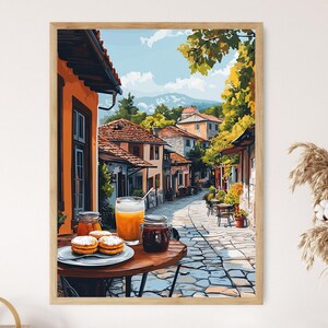 May include: A painting of a street scene in a European village. The street is cobblestone and lined with colorful buildings. There is a table with a glass of orange juice, a jar of jam, and some pastries on it.