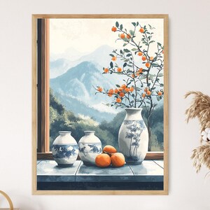 May include: A framed watercolor print featuring a serene landscape with a window view of mountains. The foreground showcases three blue and white vases, oranges, and a vase with a branch of oranges. The artwork is in a wooden frame.