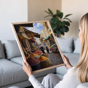 May include: A framed painting depicting a bustling marketplace in the Middle East. The scene is filled with colorful fruits, vegetables, and spices, with people shopping and vendors selling their wares. The painting captures the vibrant energy and cultural richness of the market.
