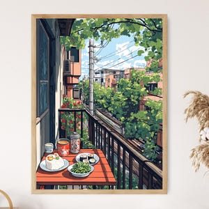 May include: A framed print of an anime-style illustration of a balcony scene. A red table is set with food and drinks. The balcony overlooks a street with buildings and lush greenery. The artwork is in a wooden frame.