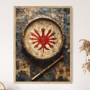 Op de afbeelding: Ingelijste kunstwerk met een ronde trommel met een rood, gestileerd ontwerp in het midden. Een houten drumstok met een rode balpunt ligt diagonaal over de trommel. De achtergrond heeft een getextureerde, verouderde uitstraling.