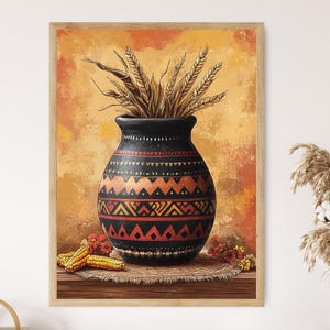 May include: A framed print featuring a black vase with a geometric pattern in red and orange. The vase holds wheat stalks. Corn and flowers are at the base of the vase. The background is a blend of orange and yellow.