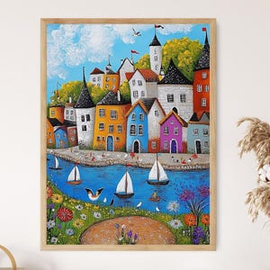 Puede incluir: Una pintura colorida de un pueblo costero con casas en varios tonos de amarillo, azul, rosa y verde. Las casas est&aacute;n agrupadas y tienen molduras blancas. Hay veleros en el agua frente al pueblo. El cielo es azul con nubes blancas.