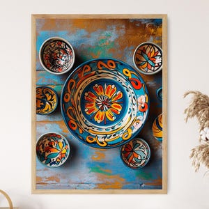 May include: A collection of colourful ceramic bowls and plates with intricate floral designs. The bowls and plates are arranged on a blue and brown wooden surface.