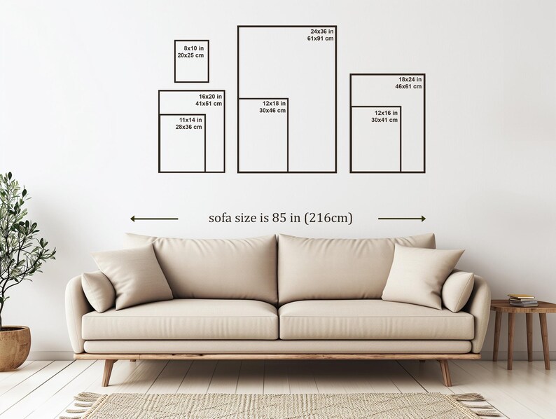 May include: A beige sofa with two throw pillows is positioned below a wall displaying framed art prints of various sizes, including 8x10 inches, 16x20 inches, 11x14 inches, 12x18 inches, 24x36 inches, 18x24 inches, and 12x16 inches. The sofa size is 85 inches (216cm).