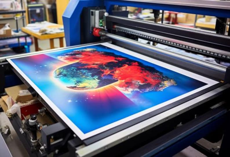 Op de afbeelding: Een grootformaatprinter print een kleurrijk beeld van een wereldbol met rode, blauwe en groene kleuren. De afbeelding wordt geprint op een wit vel papier.