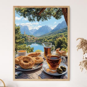 May include: A painting of a mountain lake scene with a cup of tea and a plate of sesame seed bagels on a wooden table. The lake is surrounded by trees and mountains.