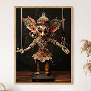 May include: A framed image of a detailed wooden puppet with a painted face, elaborate headdress, and ornate costume. The puppet has outstretched arms and is suspended by strings against a dark background. The puppet is standing on a black base.
