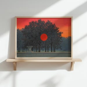 Peut inclure: Impression d'art encadrée représentant un paysage surréaliste avec un grand soleil rouge se couchant derrière une rangée d'arbres. L'œuvre d'art utilise une palette de couleurs chaudes d'orange, de rouge et de gris, et est exposée sur une étagère en bois.