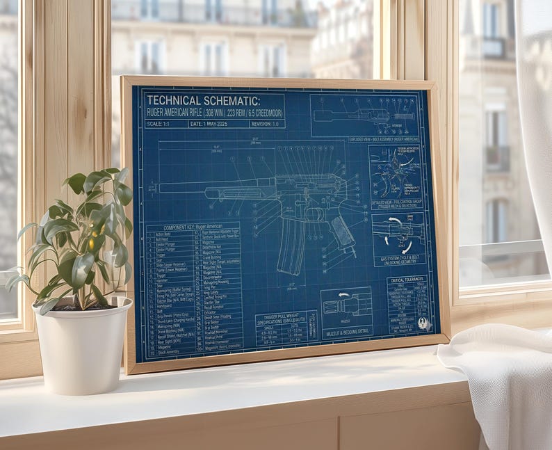 K&ouml;nnte beinhalten: Ein gerahmter Bauplan einer Ruger American Rifle mit detaillierten technischen Zeichnungen in Wei&szlig; auf blauem Hintergrund. Der Holzrahmen umgibt den Druck, der Text wie "Technical Schematic" und "Scale 1:1" enth&auml;lt. Eine Topfpflanze steht in der N&auml;he.