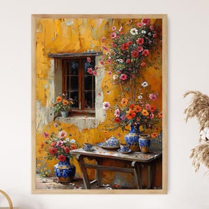 May include: A painting depicting a yellow building with a window and a floral arrangement in front of it. The flowers are in a blue and white vase and there is a small table with a teapot and cups in front of the vase.