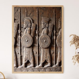 May include: A framed relief print depicting ancient warriors in profile, holding spears and shields. The artwork features detailed carvings in shades of brown and beige, with a textured background and a wooden frame.