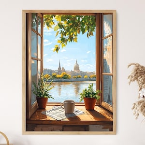 May include: A framed art print depicts a scenic view through an open window. The artwork showcases a cityscape with a river, a cup of coffee, and potted plants on a wooden sill. The sky is blue, and the scene is bathed in sunlight.