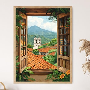 Op de afbeelding: Een ingelijste kunstdruk toont een schilderachtig uitzicht door een open raam. De scène toont een kerk, rode pannendaken en weelderig groen. Het kunstwerk is gevat in een licht houten frame, wat de kleurrijke scène versterkt.