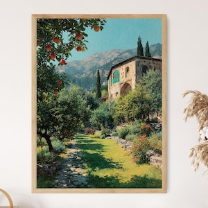 May include: A framed art print of a scenic landscape. The artwork depicts a stone building with arched windows and a turquoise door, surrounded by lush greenery, trees, and a pathway. Red apples hang from the branches of a tree in the foreground, with mountains in the background.