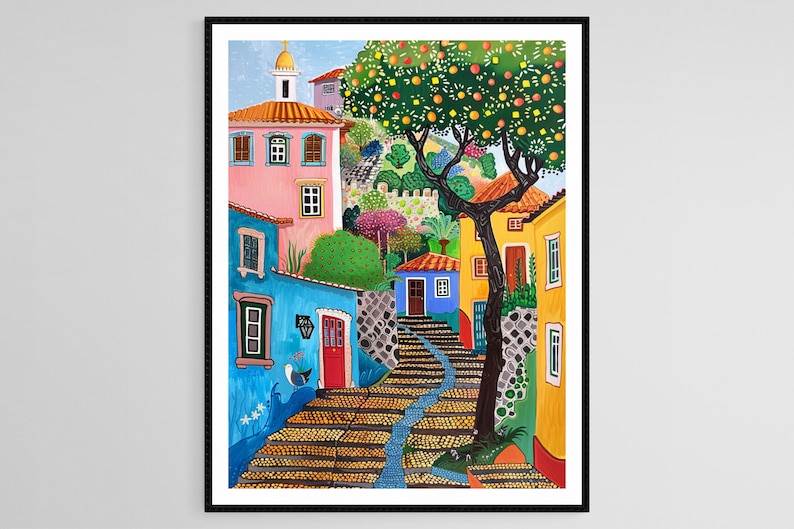 May include: Colorful art print of a European village scene. Buildings in shades of pink, blue, and yellow line a cobblestone street. A tree laden with orange fruit and a small church are visible in the background. The artwork is framed in black.