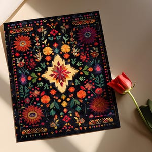 May include: A black background with a colorful floral pattern. The pattern is reminiscent of traditional Mexican embroidery. The flowers are in shades of red, orange, yellow, pink, and blue. The background is black with a subtle texture.