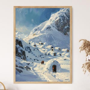 Op de afbeelding: Een ingelijste prent van een besneeuwd berglandschap met iglo-achtige structuren en een bruin dier. Het kunstwerk toont een helderblauwe lucht en een met sneeuw bedekte bergketen. De prent zit in een houten lijst.