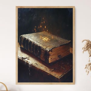 May include: A framed print depicting a large, antique book with a glowing symbol on its cover. The book sits on a wooden table, with soft, golden light illuminating the scene. The artwork has a vintage, mystical theme.